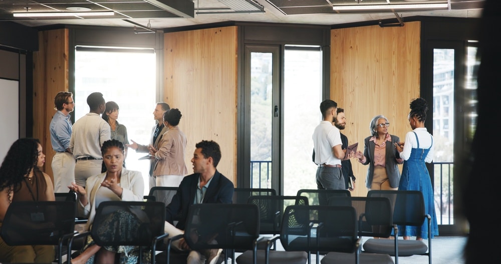 Profesionales conversando en grupos durante un encuentro en una oficina